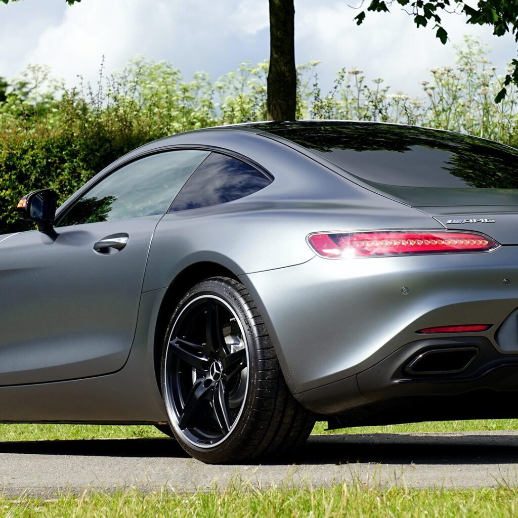 Gray Mercedes-Benz AMG GT parked on grass.